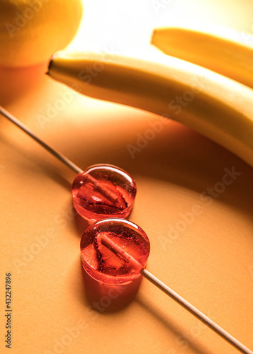 Sugar-free fruit lollipop on a minimalistic background in yellow tones. Healthy sweetness with dry fruit inside