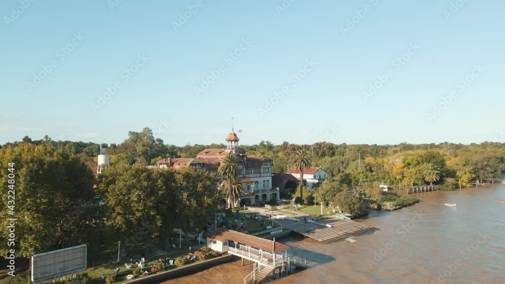 Aerial orbit of Tigre exclusive rowing club beside de la Plata river surrounded by trees at golden hour, Buenos Aires Aerial orbit of Tigre exclusive rowing club beside de la Plata river surrounded by trees at golden hour, Buenos Aires
