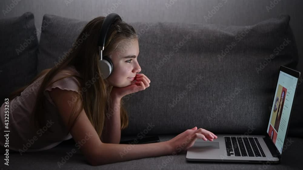 Teenage Girl Laying on a Sofa in Front of Her Laptop Teenage Girl Laying on a Sofa in Front of Her Laptop