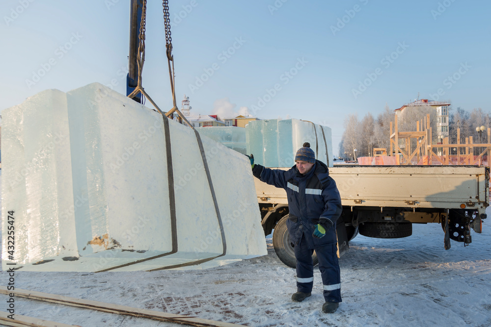 Slinger in a blue jacket unloading ice blocks Slinger in a blue jacket unloading ice blocks