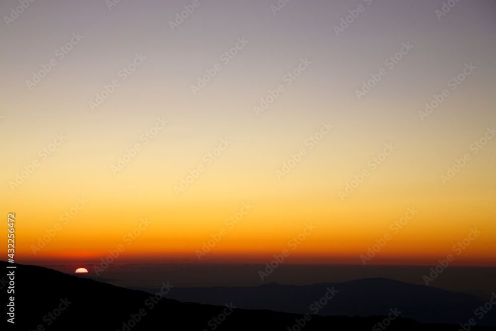 Silhouette of the mountain during a purple sunset from the Etna with clear sky and a wide horizon