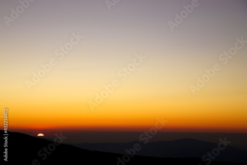 Silhouette of the mountain during a purple sunset from the Etna with clear sky and a wide horizon