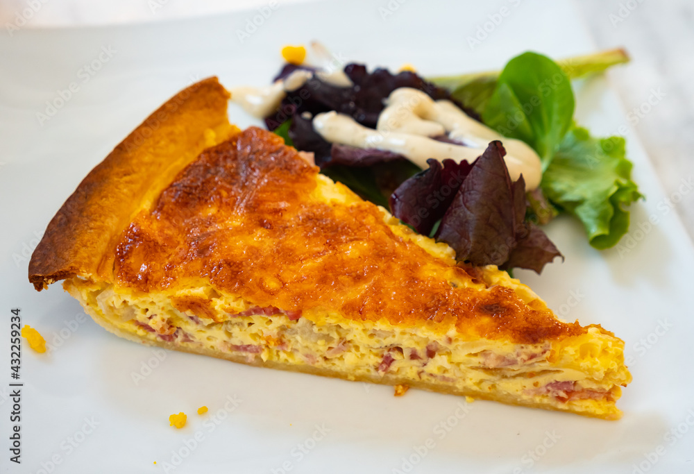 Traditional French shortcrust pastry tart Quiche Lorraine filled with savoury custard with bacon, cheese and egg