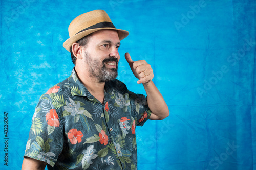 person dressed as a tourist with a printed shirt and with his hand on his face as if he were on the phone