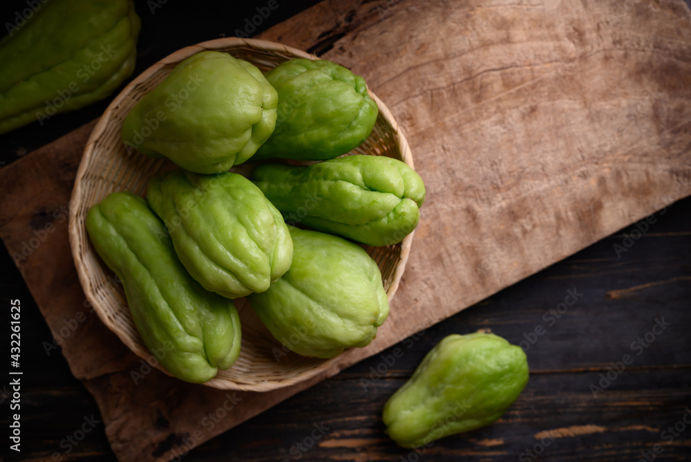 Chayote squash fruit (Mirliton, pipinola or choko) in a basket on wooden background, Edible fruit eaten both cooked and raw such as salad or salsa Chayote squash fruit (Mirliton, pipinola or choko) in a basket on wooden background, Edible fruit eaten both cooked and raw such as salad or salsa