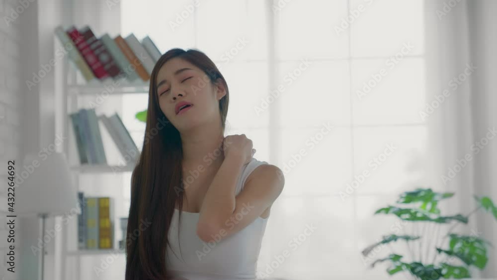 A beautiful woman in white pajamas sits on a bed in her bedroom, has severe headaches due to fever and chronic migraine attacks from cumulative stress at work. A beautiful woman in white pajamas sits on a bed in her bedroom, has severe headaches due to fever and chronic migraine attacks from cumulative stress at work.