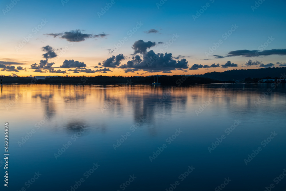 Fototapeta premium Blue hour bay waterscape with scattered clouds