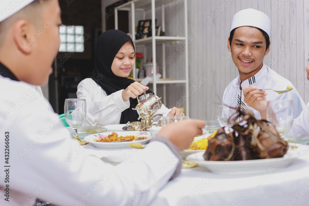 Happy family gather and eat together at dining room during Eid Mubarak celebration Happy family gather and eat together at dining room during Eid Mubarak celebration