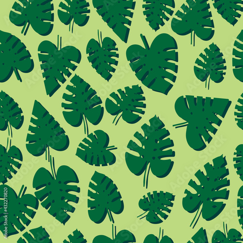 Seamless pattern with green tropical monstera leaves with dark shade on a pastel yellow background. Vector, eps 10.