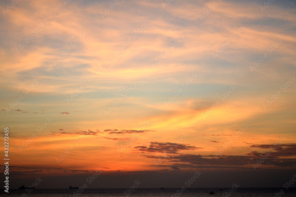 Dramatic sunset. Orange-violet sky. The sun behind the clouds. Landscape.