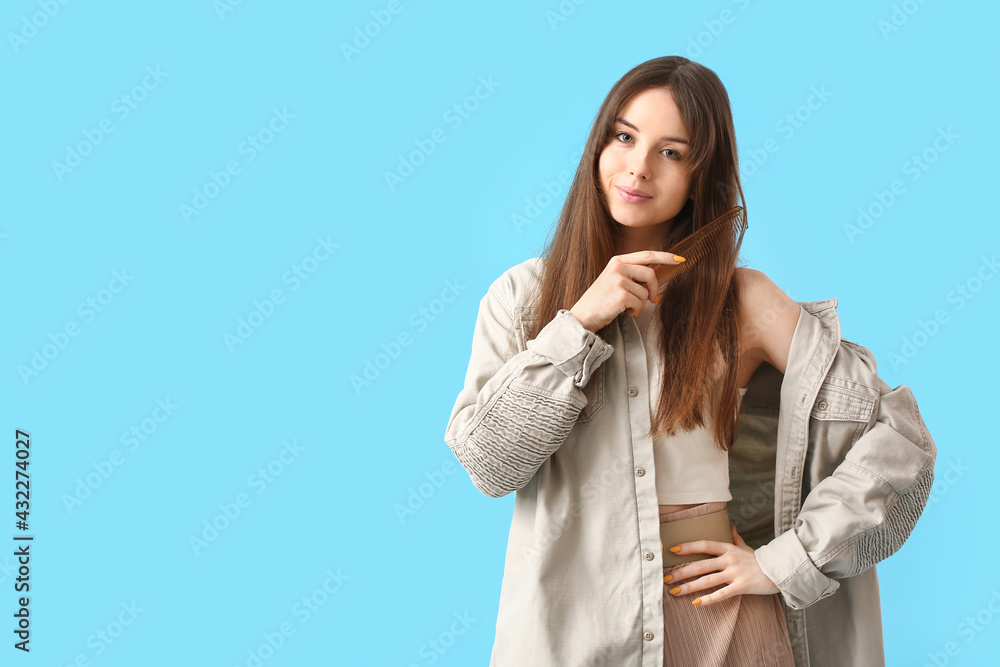 Beautiful young woman with hair comb on color background Beautiful young woman with hair comb on color background