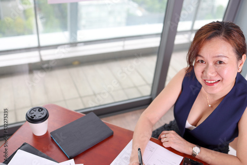 beautiful attractive middle age southeast asian woman home office work study sit at table paper note book lap top coffee cup smart phone pen look forward front urban daylight window background Free Download beautiful attractive middle age southeast asian woman home office work study sit at table paper note book lap top coffee cup smart phone pen look forward front urban daylight window background - GFXLoad
