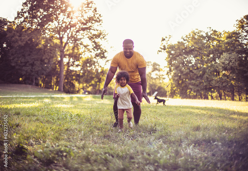 African American father and daughter having fun in the park.