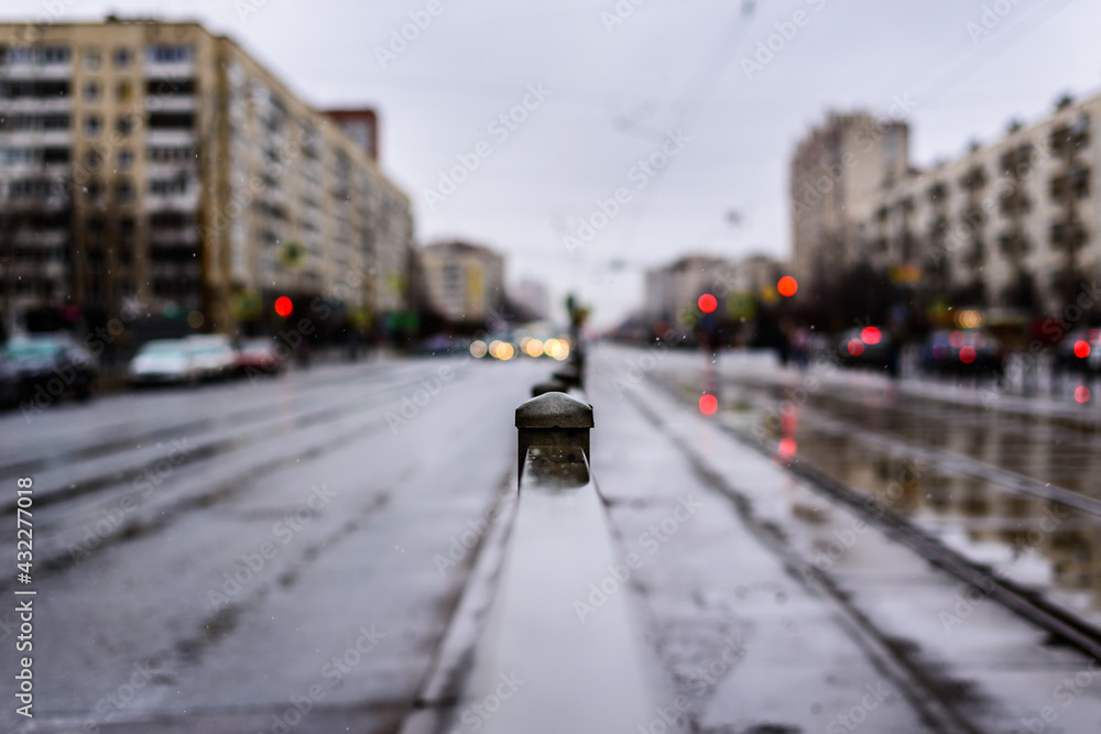 Rainy day in the big city, the empty road. Close up view, from the handrail on the sidewalk level