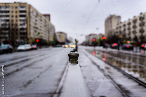 Rainy day in the big city, the empty road. Close up view, from the handrail on the sidewalk level