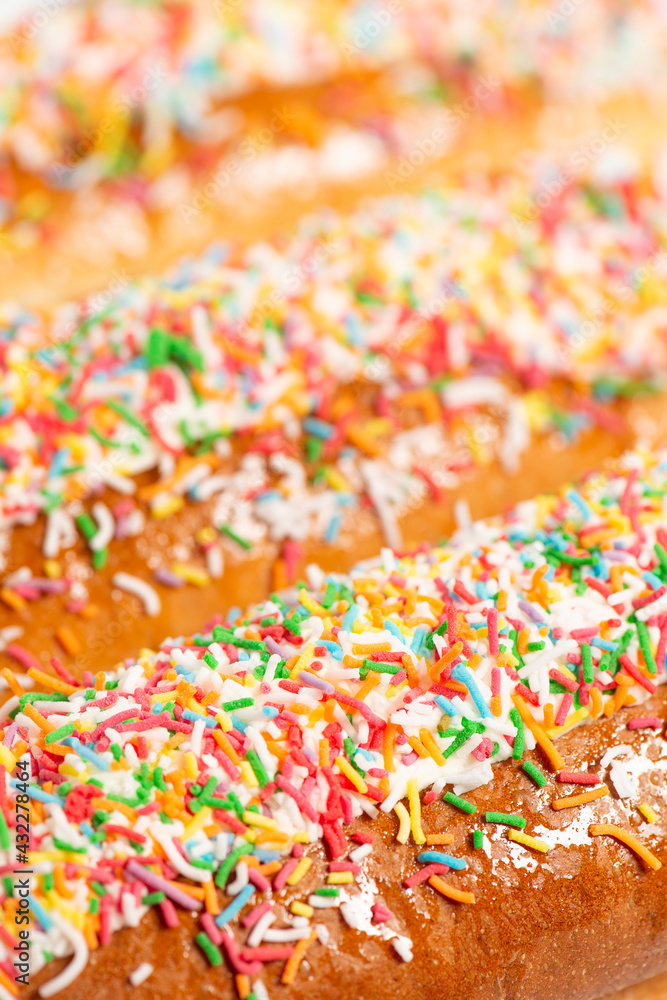 Freshly baked iced finger buns with rainbow sprinkles