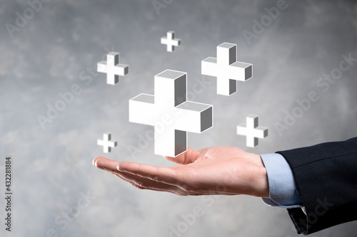 Businessman hold 3D plus icon, man hold in hand offer positive thing such as profit, benefits, development, CSR represented by plus sign.The hand shows the plus sign