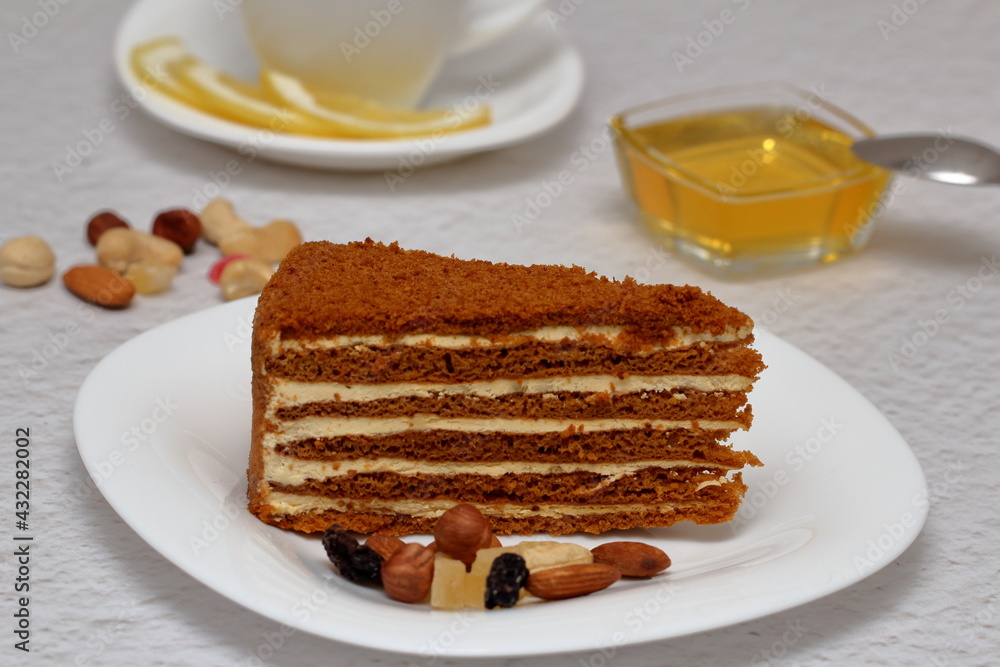 honey cake on a plate with nuts and tea for dessert honey cake on a plate with nuts and tea for dessert