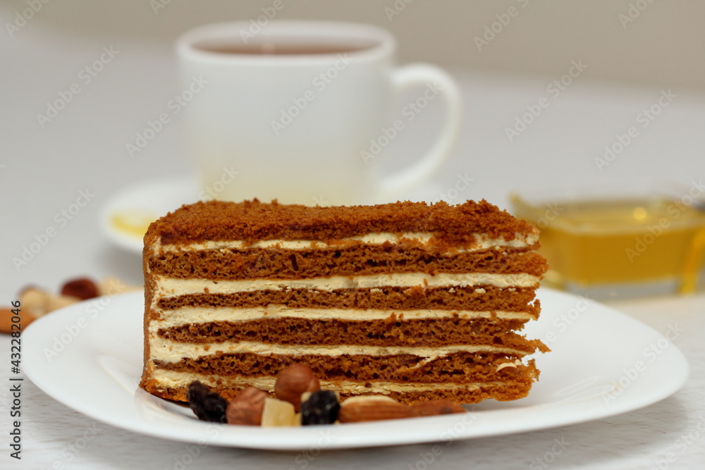 honey cake on a plate with nuts and tea for dessert honey cake on a plate with nuts and tea for dessert