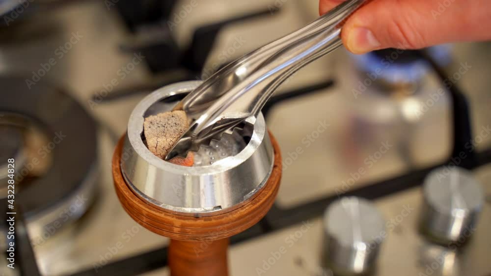 Closeup of burning embers on hookah. Media. Square red coals ignite