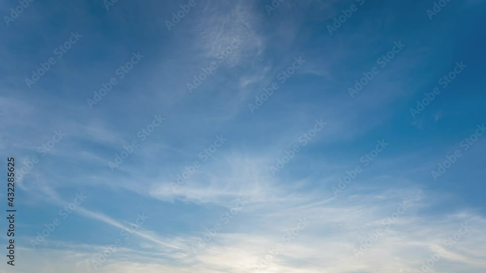 Blue sky video background. Time lapse of beautiful sunset peaceful clear sunny spring sunset sky with soft delicate white clouds moving along Blue sky video background. Time lapse of beautiful sunset peaceful clear sunny spring sunset sky with soft delicate white clouds moving along