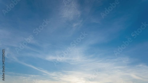 Blue sky video background. Time lapse of beautiful sunset peaceful clear sunny spring sunset sky with soft delicate white clouds moving along