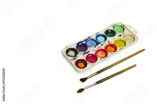 Watercolor paints and brushes, top view. Hobbies and creativity. white background. Set of colorful paints palette