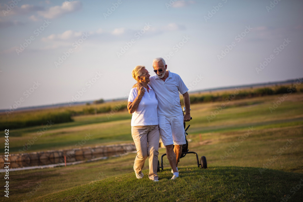 Fototapeta premium Senior golfers talking and walking on golf course.