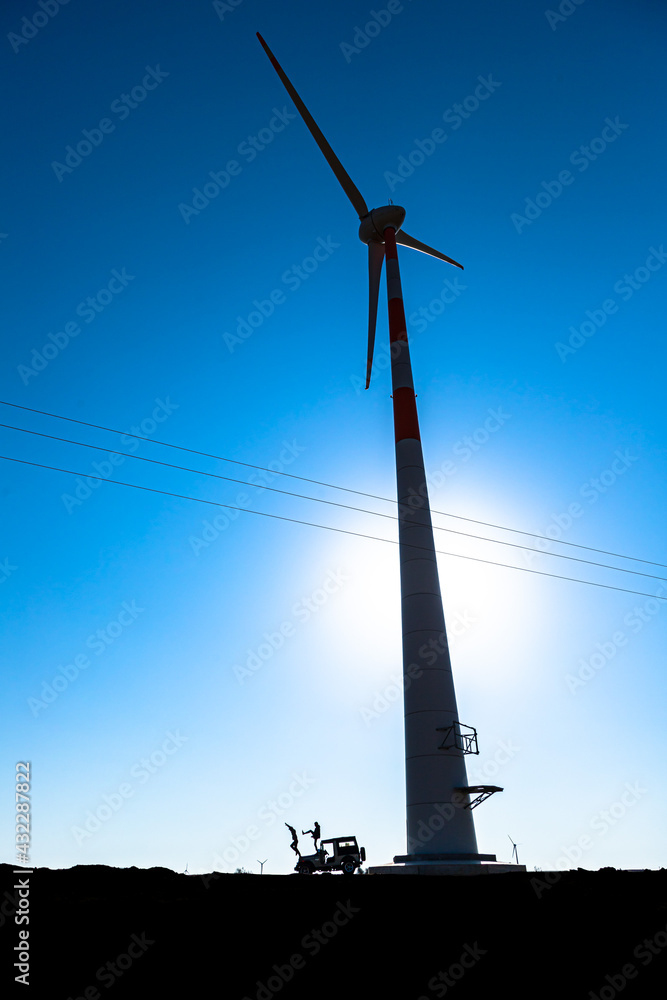 two man jumping from thar jeep and behind is windmill in jaisalmer area of rajasthan. two man jumping from thar jeep and behind is windmill in jaisalmer area of rajasthan.
