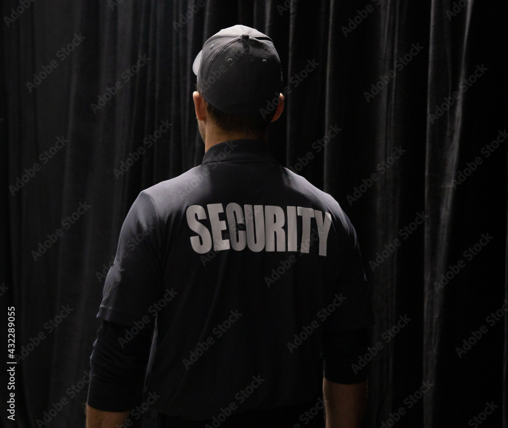 Obraz premium Rear view of security guard in uniform patrolling in commercial mall