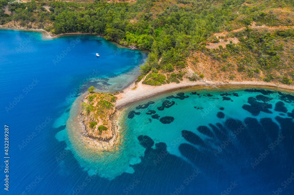 Aerial view of clear turquoise water near the rocky coast of the Aegean Sea, Turkey.