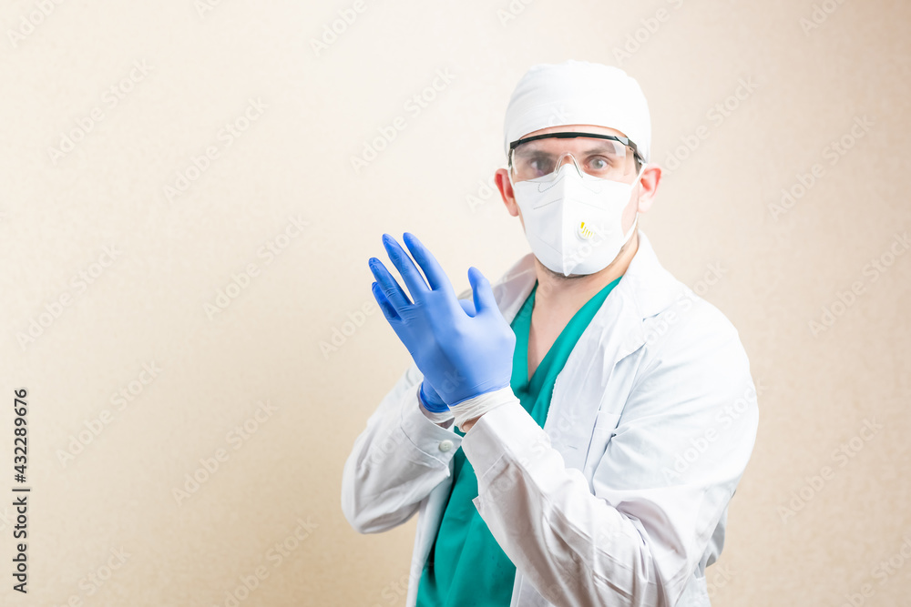 The doctor puts on gloves. On a light background. The doctor puts on gloves. On a light background.