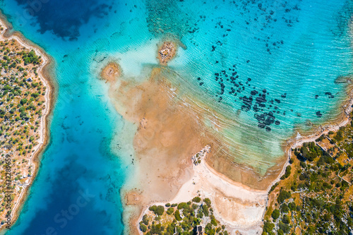Aerial view of clear turquoise water near a tropical island in the Caribbean.