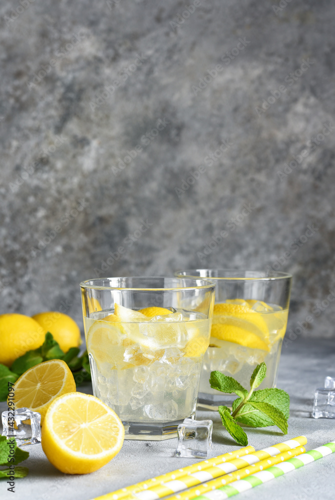 Cold lemonade with lemon, mint and ice on a concrete background. Cold lemonade with lemon, mint and ice on a concrete background.