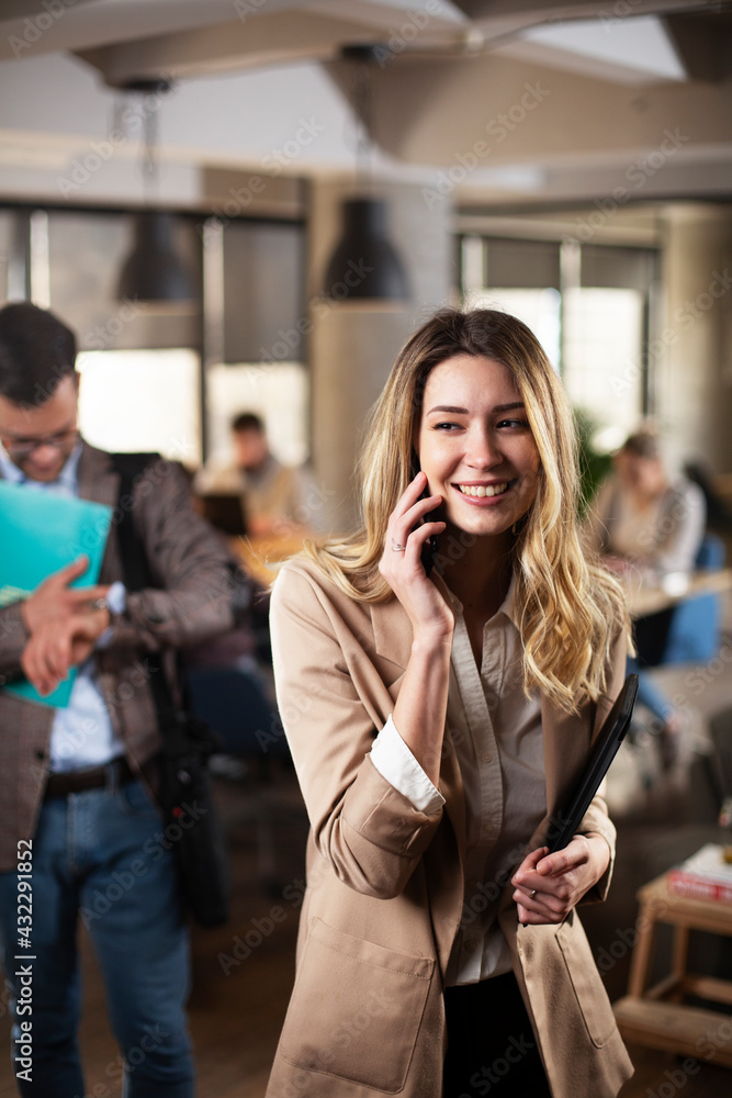 Businesswoman in office. Smiling businesswoman talking to the phone.