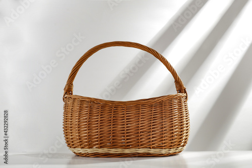 Wooden basket of free space for your decoration and white wall with shadows 