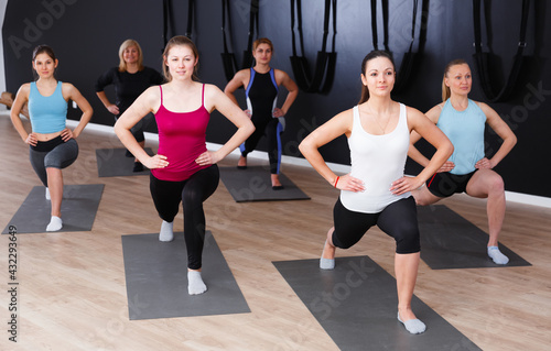 Young sporty women practicing yoga positions during training at gym