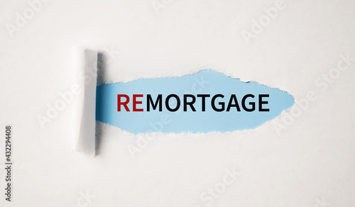 Remortgage text on torn light blue paper. Fiancial concept. photo