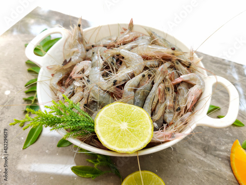 Fresh White Prawns decorated in a white bowl with herbs and fruits.Selective focus. photo