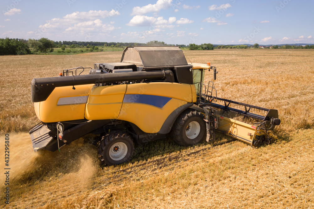 Aerial view of combine harvester harvesting large ripe wheat field. Agriculture from drone view. Aerial view of combine harvester harvesting large ripe wheat field. Agriculture from drone view.