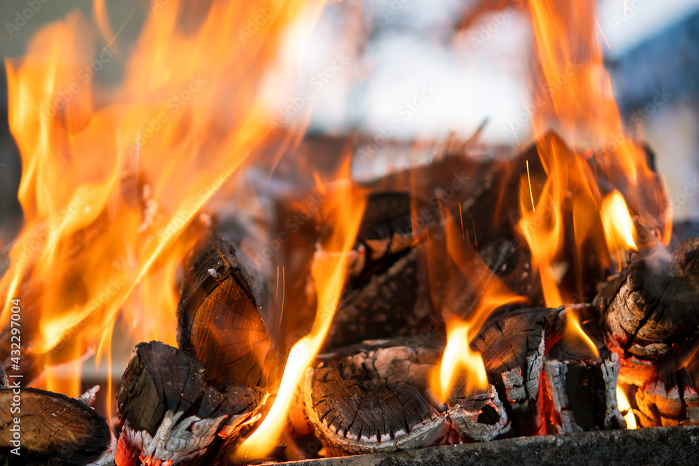 Close up of brightly burning wooden logs with yellow hot flames of fire at night. Close up of brightly burning wooden logs with yellow hot flames of fire at night.