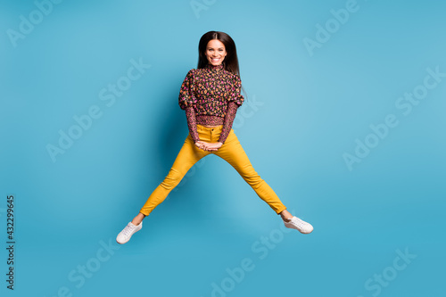 Full size photo of young attractve smiling modest cheerful good mood positive woman jump fly isolated on blue color background photo