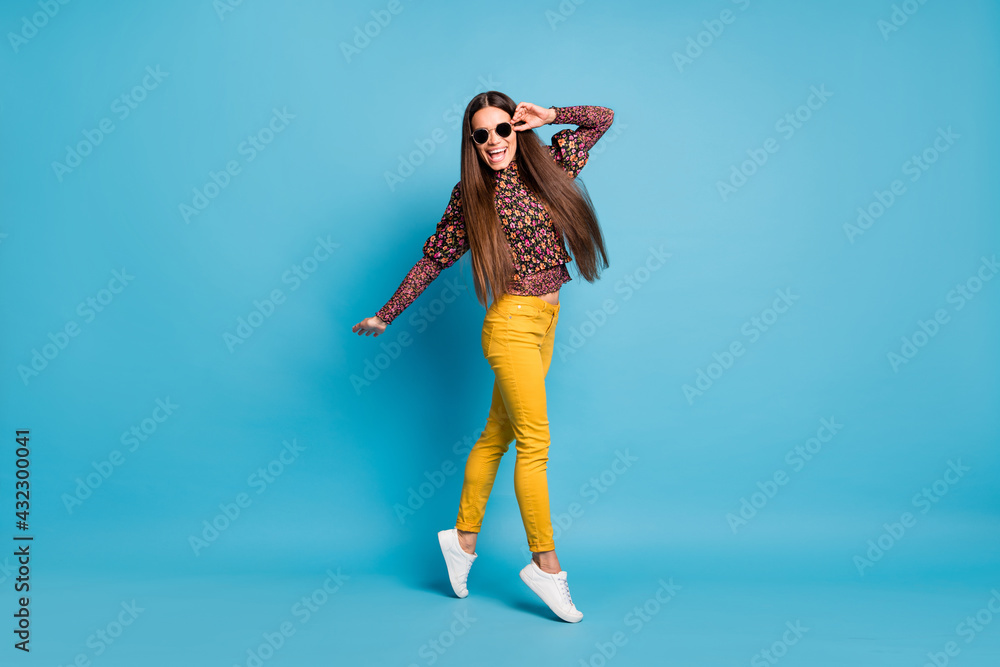 Full size photo of young cheerful good mood smiling carefree woman dance touch sunglasses isolated on blue color background
