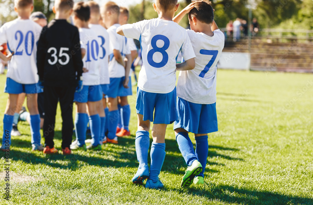 Obraz premium Boys in School Sports Team on the Field. Kids in a Group With Soccer Coach. Children Playing Football Match. Game Break in a Football Match