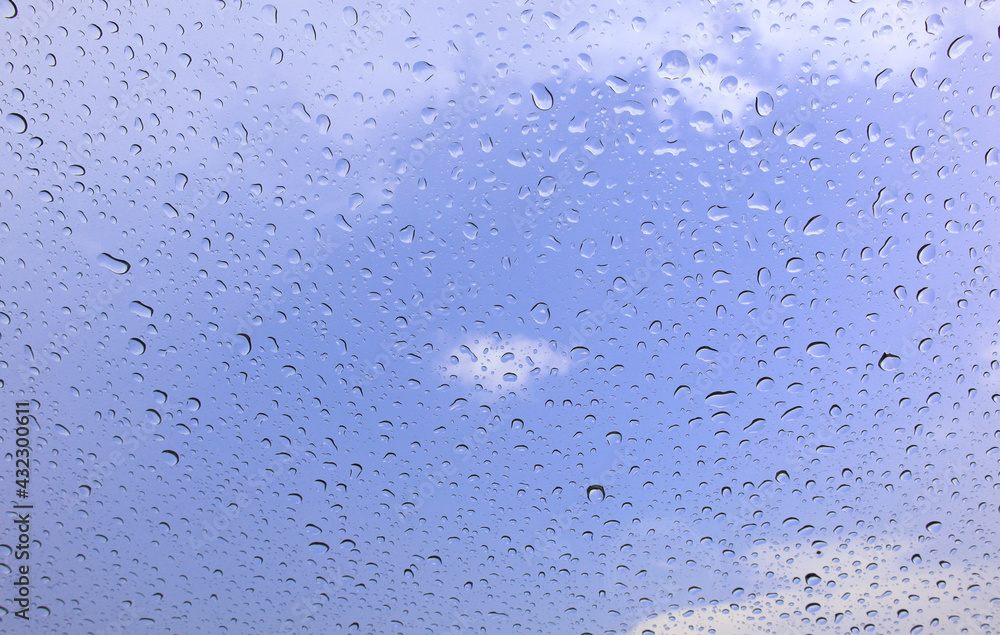 Rain drops cling to the car windows on a rainy day Blurred background blue sky Rain drops cling to the car windows on a rainy day Blurred background blue sky