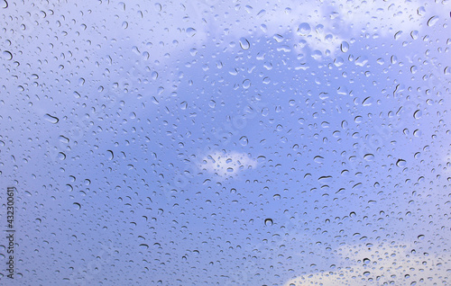 Rain drops cling to the car windows on a rainy day Blurred background blue sky