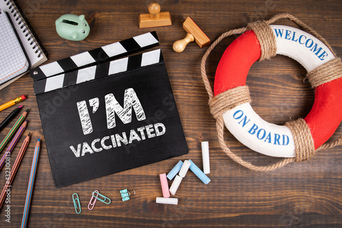 I'm Vaccinated. Virus spread, travel and business concept. Movie clapper on a wooden office desk