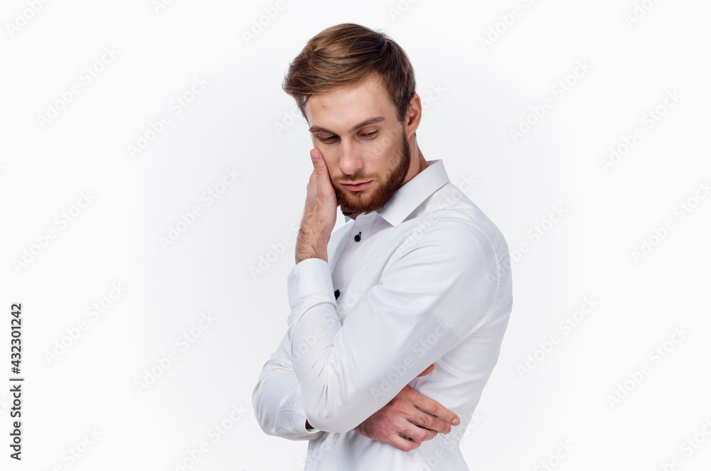 handsome young man in shirt touches his face with hand side view light background handsome young man in shirt touches his face with hand side view light background