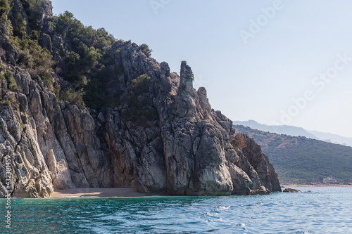 Small picturesque beach surrounded by rocks, clear turquoise water and morning light haze, Albania. Travel theme, beautiful nature