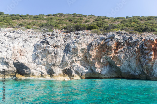 Amazing turquoise sea and cliffs surrounded by green plants, Albania. Travel theme, beautiful nature